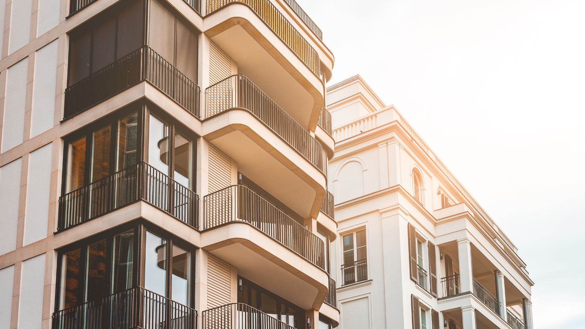Modern residential building with curved balconies and warm sunlight