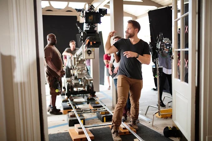 Behind-the-scenes of film production with camera equipment and crew