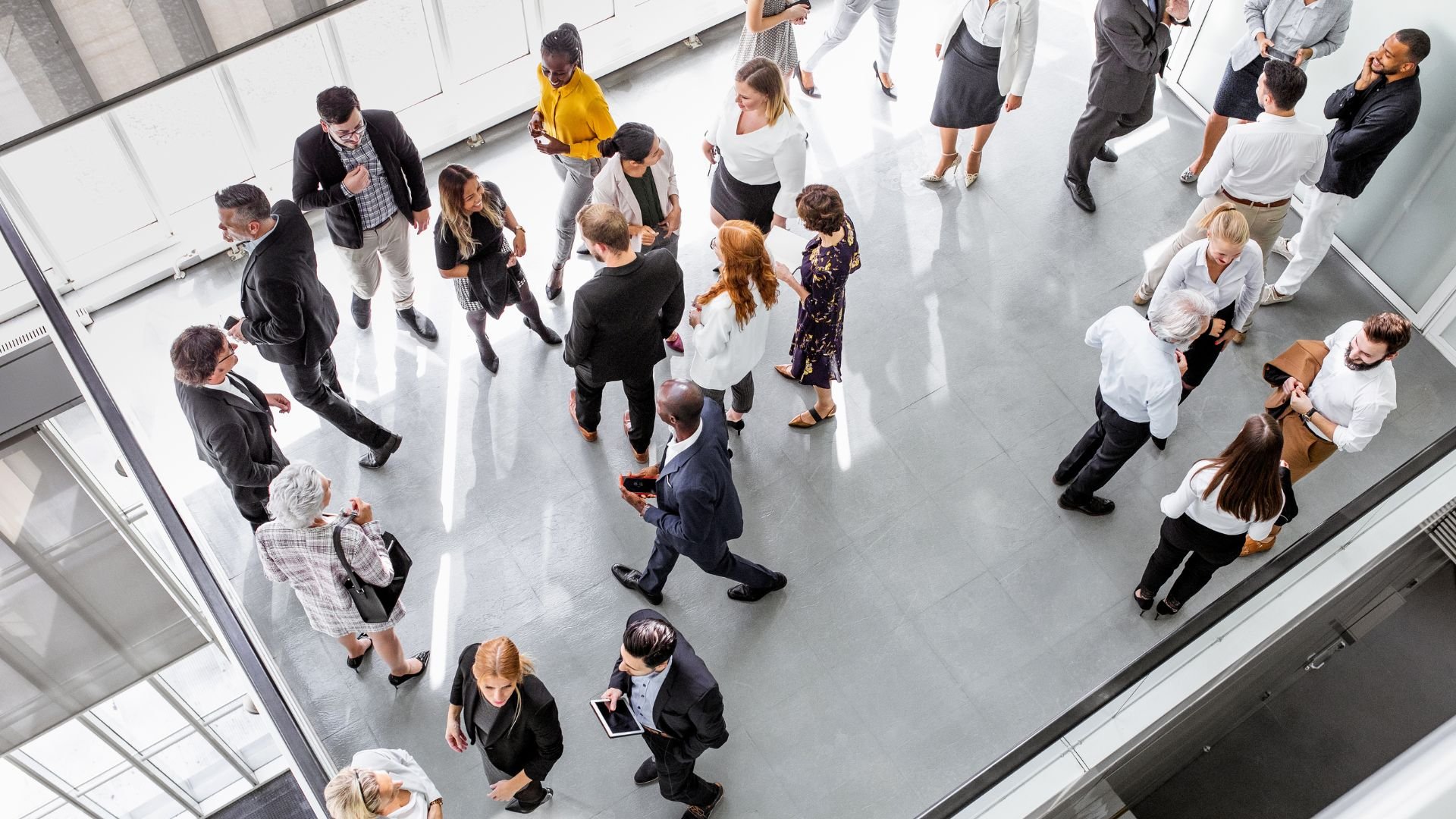 Diverse business professionals networking in modern, bright office lobby