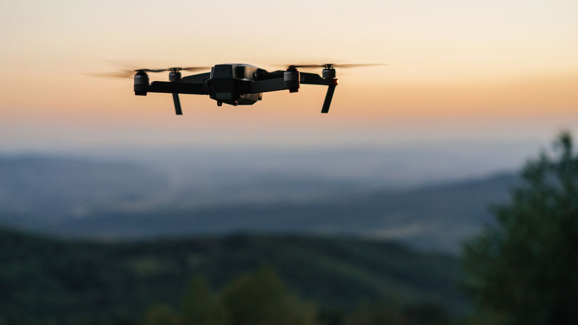 Drone flying at sunset over misty mountainous landscape